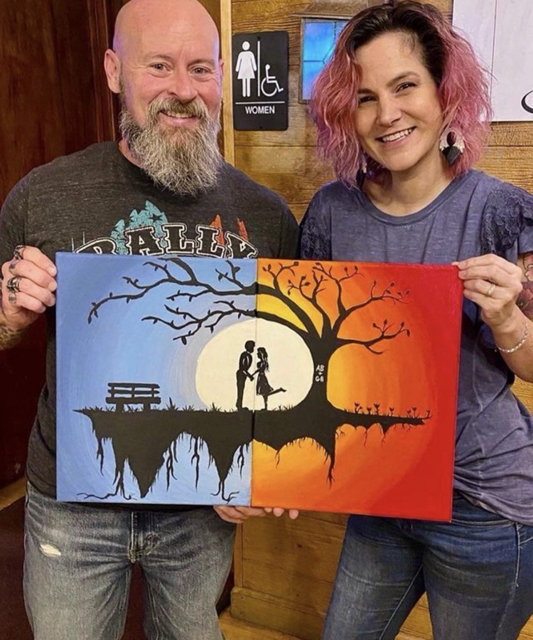 A couple holding a painting they made